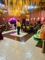 Un uomo in piedi di fronte a una stanza con una folla di Hotel Govindam Elite a Juhi Bari