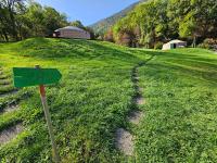 a green sign in the middle of a field at Yourtes Olachat proche Annecy in Faverges
