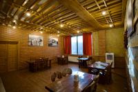 Un restaurante con mesas y sillas de madera en una sala. en Hotel Mogzauri, en Tiflis