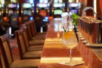 un bicchiere di vino appoggiato su un bancone in un ristorante di Hotel y Casino del Río - Viedma a Viedma