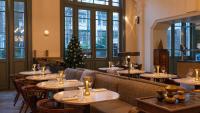 アムステルダムにあるHotel Mercierのテーブルと椅子、クリスマスツリーのあるレストラン