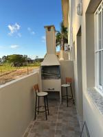 a balcony with two stools and a fish tank at Loft incrível e completo in São Lourenço do Sul
