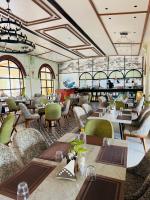 a restaurant with tables and chairs and a bar at Jaladarshini Lakeside Gardens in Kollam