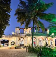 a building with a palm tree in front of it at Jaladarshini Lakeside Gardens in Kollam
