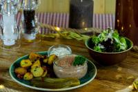 a plate of food with a salad and a bowl of dip at Teutsche Schule in Schleusingen