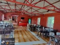 een eetkamer met tafels en stoelen in een gebouw bij The Amba Resort in Chandoli