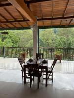 un patio con mesa de comedor y sillas en Kitulgala Ebony Riverside Resort, en Kitulgala