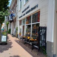 una cafetería con mesas y sillas frente a un edificio en ApartHotel Waepen van Middelburg, en Middelburg