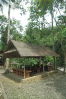 a pavilion with tables and chairs and a straw roof at AUM Resort in Pulukan