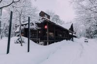 a building covered in snow in the snow at Double Black Hotel in Hakuba