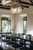 Un comedor con mesas, sillas y candelabros. en The Project Cafe and Hotel, en Aldona