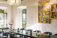 una habitación con mesas y sillas y un cuadro en la pared en The Project Cafe and Hotel, en Aldona