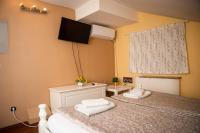 Un dormitorio con dos camas y un televisor en la pared. en Hostel Iris, en Belgrado
