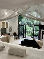 a bedroom with a bed and a kitchen with a large window at Gallery Walk Chalets - Tamborine Mountain in Mount Tamborine