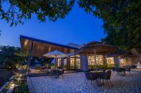 an outdoor patio with tables and umbrellas at night at Mahavan Resort in Chitrod
