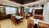 a dining room with tables and chairs in a restaurant at Hotel Akshaya in Port Blair