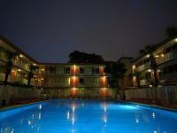 Una gran piscina frente a un edificio por la noche. en Red Carpet Inn Airport Fort Lauderdale, en Fort Lauderdale