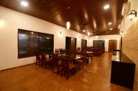 een eetkamer met houten tafels en stoelen. bij Waves and Vibes Resort in Lavasa