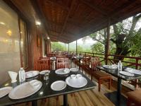 een eetkamer met tafels en stoelen en een balkon bij Waves and Vibes Resort in Lavasa