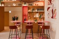 ラ・ロシェルにあるCENTRAL Hôtel La Rochelle Centreの棚のある部屋にピンクのスツールが置かれたバー