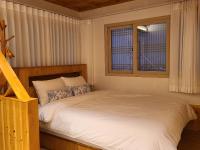 ein Schlafzimmer mit einem Bett und zwei Fenstern in der Unterkunft Hanok stay Mokhyang in Gyeongju