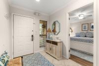 ein Schlafzimmer mit einem Bett, einem Waschbecken und einem Spiegel in der Unterkunft Fairways 228 &quot;Bluegrass Bungalow&quot; in Destin