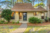 ein kleines gelbes Haus mit einer steinernen Einfahrt in der Unterkunft Fairways 228 &quot;Bluegrass Bungalow&quot; in Destin