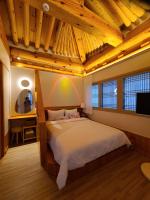 ein Schlafzimmer mit einem großen Bett und einer Holzdecke in der Unterkunft Hanok stay Mokhyang in Gyeongju