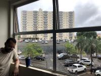 a man looking out of a window at a parking lot at Golden Dolphin Express in Caldas Novas