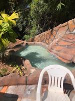 a white chair sitting next to a swimming pool at Golden Dolphin Express in Caldas Novas