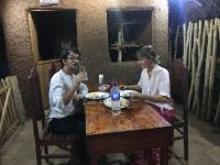 a man and a woman sitting at a table at Jungle Edge Cottage in Udawalawe