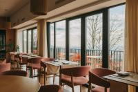 Un restaurante con mesas y sillas y grandes ventanales. en Estrela Serenity - Resort, en Folgosinho