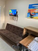 a living room with a couch and a table and a tv at Loft incrível e completo in São Lourenço do Sul