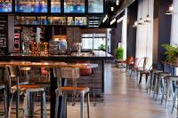 a bar in a restaurant with tables and chairs at MOXY New Orleans Downtown/French Quarter Area in New Orleans