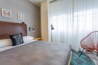 a bedroom with a bed and a chair and a window at MOXY New Orleans Downtown/French Quarter Area in New Orleans