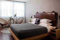 a bedroom with a bed and chairs and a window at MOXY New Orleans Downtown/French Quarter Area in New Orleans