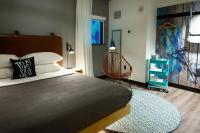 a bedroom with a large bed and a chair at MOXY New Orleans Downtown/French Quarter Area in New Orleans