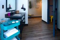 a bathroom with a sink and a shelf with towels at MOXY New Orleans Downtown/French Quarter Area in New Orleans