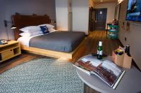 a bedroom with a bed and a table and a rug at MOXY New Orleans Downtown/French Quarter Area in New Orleans