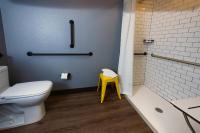 a bathroom with a white toilet and a yellow stool at MOXY New Orleans Downtown/French Quarter Area in New Orleans