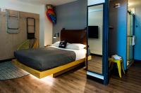 a bedroom with a bed and a mirror at MOXY New Orleans Downtown/French Quarter Area in New Orleans