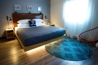 a bedroom with a bed with a blue blanket and a window at MOXY New Orleans Downtown/French Quarter Area in New Orleans