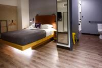 a bedroom with a bed and a bathroom at MOXY New Orleans Downtown/French Quarter Area in New Orleans
