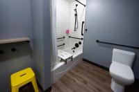 a bathroom with a white toilet and a yellow stool at MOXY New Orleans Downtown/French Quarter Area in New Orleans