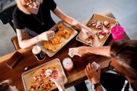 a group of people sitting at a table eating food at MOXY New Orleans Downtown/French Quarter Area in New Orleans