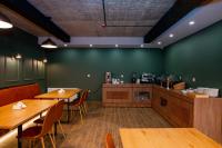 a restaurant with wooden tables and a green wall at Gоderdzi Twins Hotel in Goderdzi