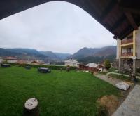 Una vista de un patio verde con montañas al fondo. en Kris Guest House, en Devin