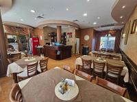 un restaurant avec des tables, des chaises et un comptoir dans l'établissement Family Hotel Jeri, à Velingrad