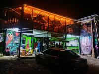 een auto die 's nachts voor een gebouw geparkeerd staat bij Hospedaje Puerta al Lago in Suse