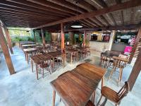 un ristorante vuoto con tavoli e sedie di legno di Pousada do Sol - Ponta Verde a Maceió